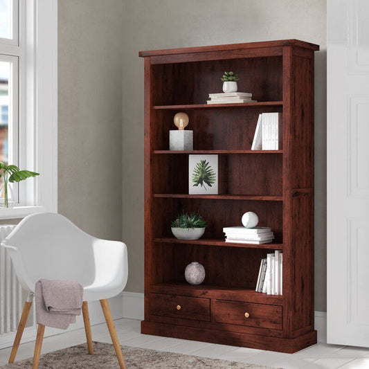 A room with a bookcase filled with books and a chair in the corner.