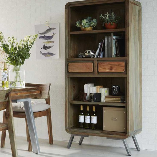 A wooden bookcase with a table and chairs in a cozy reading nook.