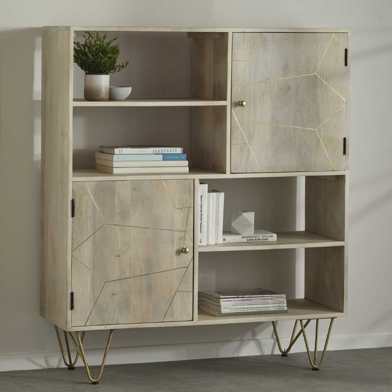 A gold metal framed bookcase with shelves holding various books and decorative items.