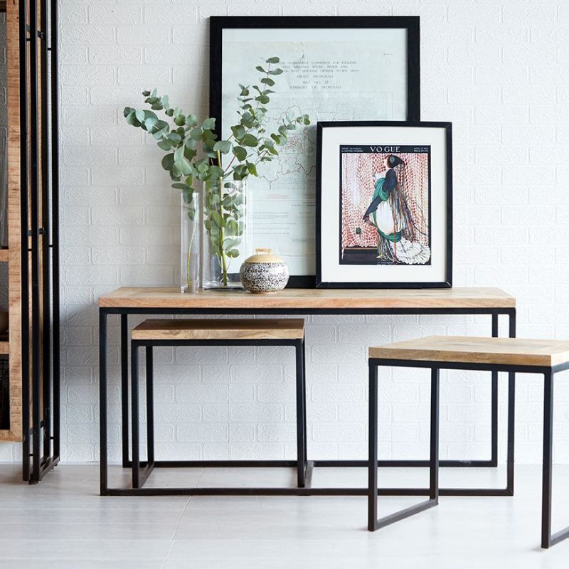 An intimate space featuring a small table, two stools, and a framed picture.