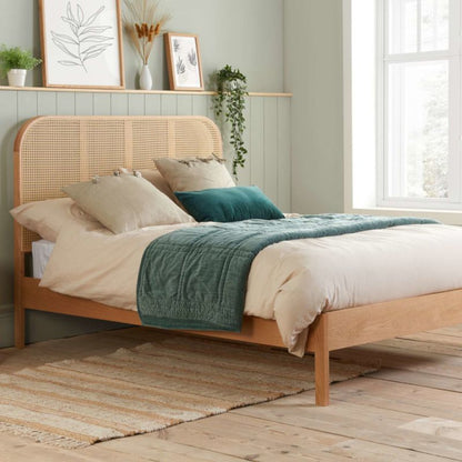 Wooden bed frame with green blanket.