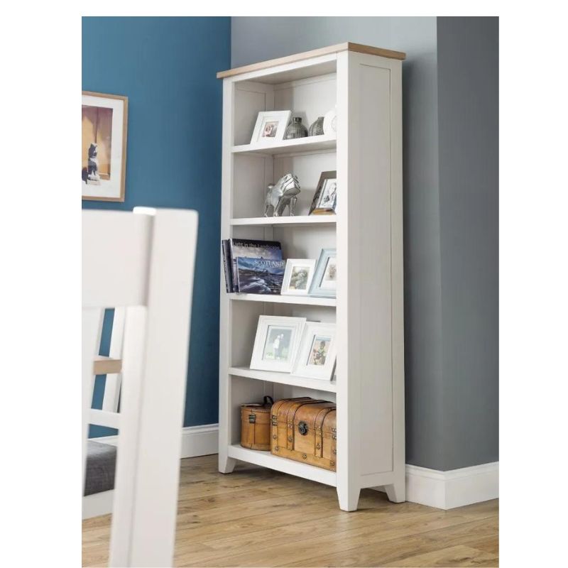 A white bookcase adorned with various pictures, showcasing a blend of personal memories and decorative elements.