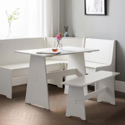 A white kitchen table accompanied by two matching benches, creating a clean and inviting dining space.