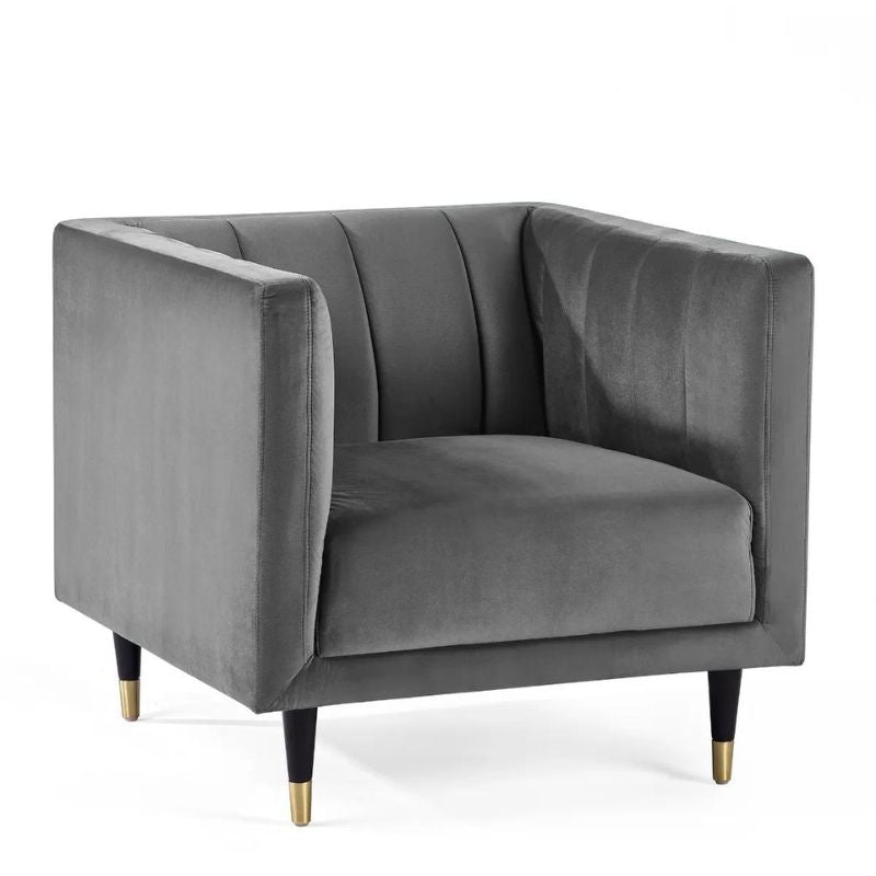 A grey velvet chair featuring elegant gold legs, showcasing a blend of luxury and modern design in a stylish setting.