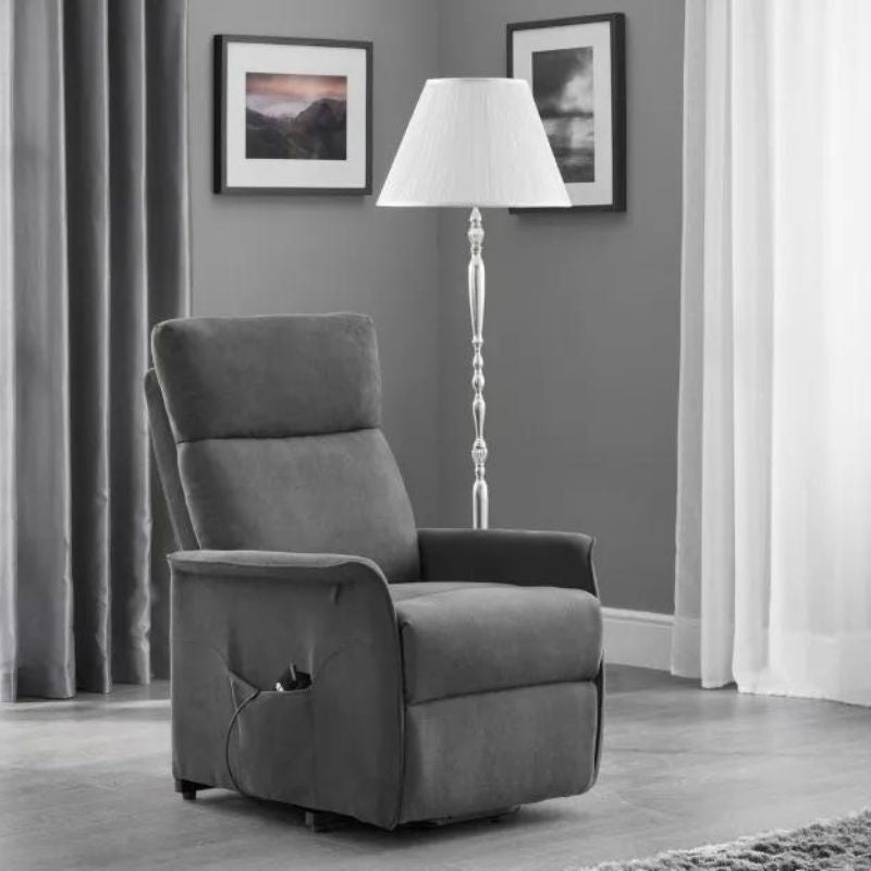 A grey recliner chair positioned in a cozy room, accompanied by a stylish lamp providing warm illumination.