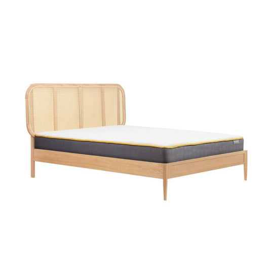 A bed with a sturdy wooden frame and a plush mattress, emphasizing a classic and inviting aesthetic.