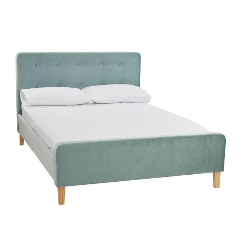 A bed featuring a blue headboard and wooden legs, elegantly designed for a stylish bedroom setting.