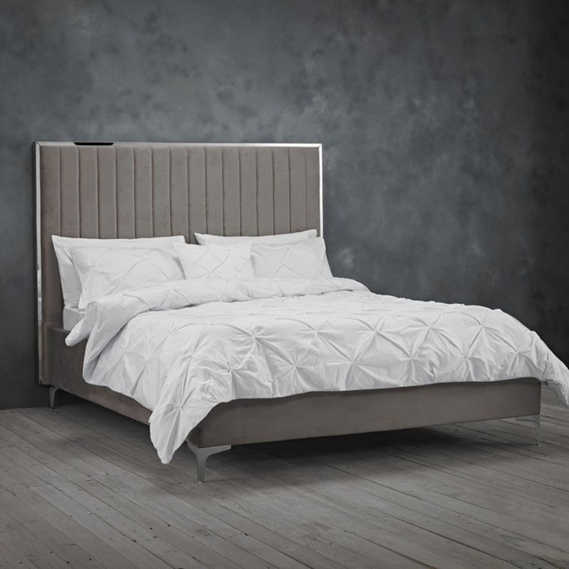 A neatly made bed featuring a white headboard and soft gray sheets, creating a serene and inviting atmosphere.