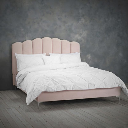 A cozy bed featuring a pink headboard adorned with crisp white sheets, creating a warm and inviting atmosphere.