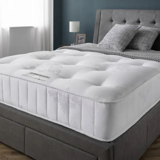 A mattress covered with a crisp white cover, showcasing a clean and minimalist aesthetic.