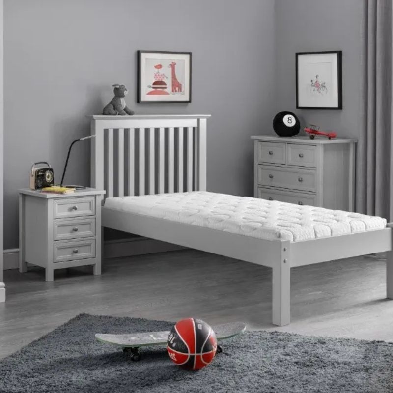 A grey bedroom featuring a bed, a nightstand, and a basketball on the floor, creating a cozy and sporty atmosphere.