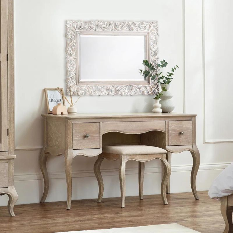 A cozy bedroom featuring a stylish dressing table with an elegant mirror, creating a serene and inviting atmosphere.