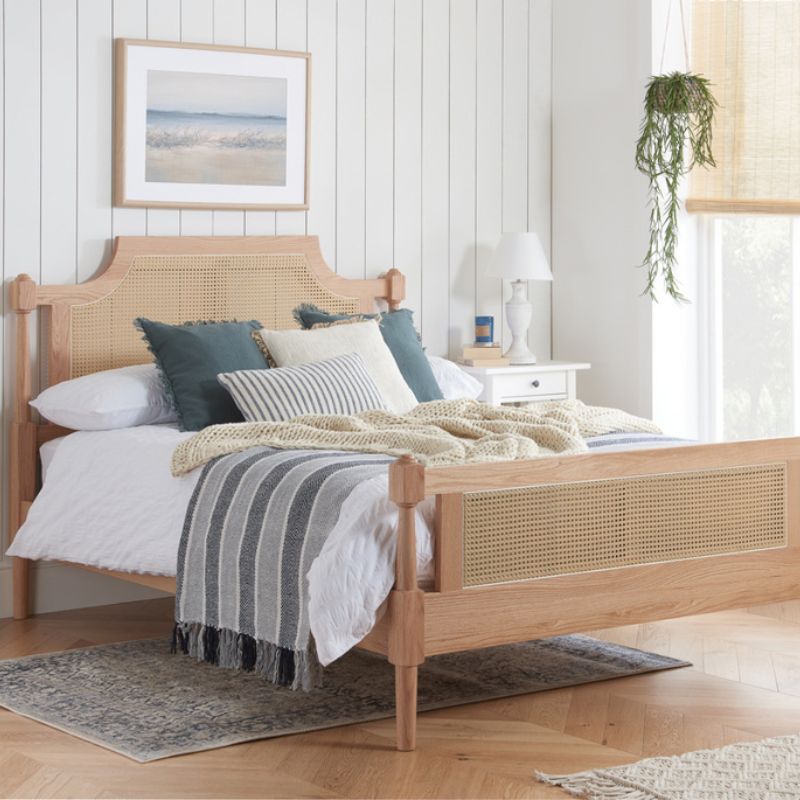 A wooden bed frame adorned with a blue and white striped blanket, creating a cozy and inviting atmosphere.