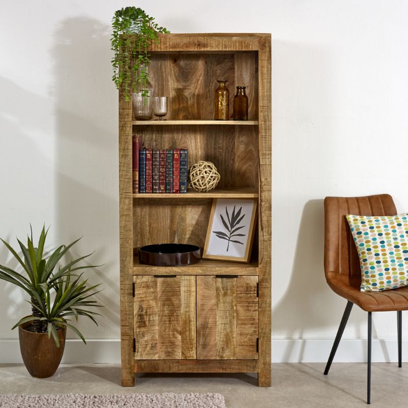 A rustic wooden bookcase with a chair and plant.