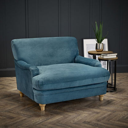 Stylish blue velvet chair on hardwood floor.