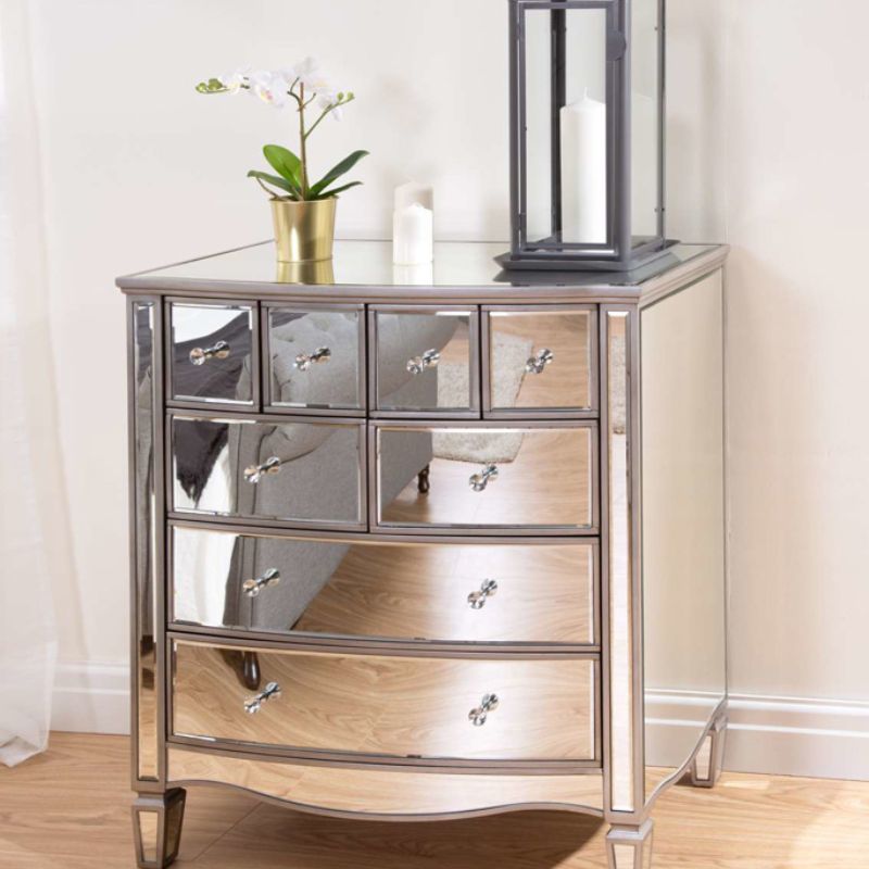 Elegant silver chest with drawers and a decorative vase.